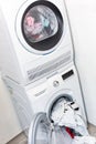 Electric dryer with clothes inside and washer in the laundry room Royalty Free Stock Photo