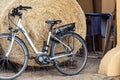 Electric eco green energy power hybrid e-bike parked against big hay straw bale at rural farm yard. Sustainable healthy Royalty Free Stock Photo