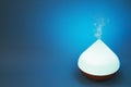 Electric essential oil diffuser on blue background