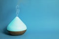 Electric essential oil diffuser isolated on blue background