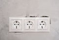 Electric EU socket outlet on gray concrete wall background. Repair in an apartment or in office, replacement of Royalty Free Stock Photo