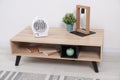 Electric fan heater and different decor elements on wooden coffee table at home Royalty Free Stock Photo