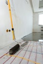 Electric floor heating system installation in new house. Closeup of the rooler for align concrete. Royalty Free Stock Photo