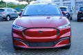 Electric Ford Mustang Mach-E on display in parking lot of company store specializing in sale of electric vehicles, alternative