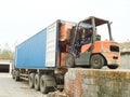 Electric Forklift Loading Cargos into Container