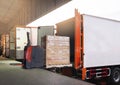 Electric Forklift Loading Shipment Boxes into Cargo Container. Cargo Trailer Truck Parked Loading at Dock Warehouse. Royalty Free Stock Photo