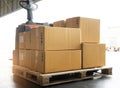 Electric forklift pallet jack loading shipment boxes. Stack package boxes on pallet.