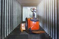 Electric Forklift Pallet Jack with Package Boxes in Cargo Container. Warehouse Shipping, Supply Chain, Shipment, Cargo Transport. Royalty Free Stock Photo