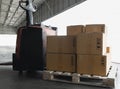 Electric forklift pallet jack with stack shipment boxes on pallet. Cargo export & shipping warehousing.