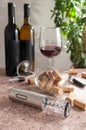 Electric gray metal corkscrew, aerator and vacuum stopper for wine. On a brown background. In the background are two bottles of