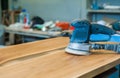 Electric grinder on a board in a carpentry workshop. Close-up. Copy space Royalty Free Stock Photo