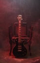 Black electric guitar and amplified on chair with smoke