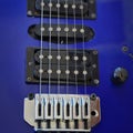 Electric guitar bridge, strings and pickup. Detail close-up view of guitar pickup in blue Royalty Free Stock Photo