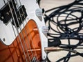 Electric guitar with detailed close-up showing strings, knobs, and tangled cables in a music studio setting