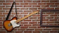 An electric guitar is hanging on a brick wall Royalty Free Stock Photo