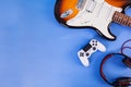 Electric guitar, joystick, headphones. Pop culture media attributes. Top view Royalty Free Stock Photo
