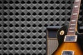 Electric guitar leaning on Guitar Amplifier Combo over acoustic foam panel background Royalty Free Stock Photo