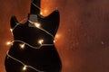 Electric guitar with lighted garland on brown grunge background Royalty Free Stock Photo