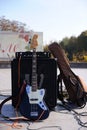 Electric guitar put against the column speaker on the empty stage, city park Royalty Free Stock Photo
