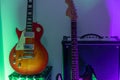 Electric guitars and amplifier against a wall with rgb lights Royalty Free Stock Photo