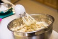 Electric hand mixer kneads dough in a deep bowl Royalty Free Stock Photo