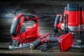 Electric hand tools red corded jigsaw cordless drill and small plunge router milling machine portable mini wood router on vintage Royalty Free Stock Photo