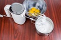 Electric handheld mixer, beaten eggs and broken eggs in bowl Royalty Free Stock Photo