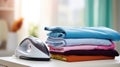 Electric iron and pile of clothes on ironing board Royalty Free Stock Photo