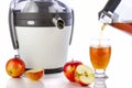 Electric juicer and apple juice pouring in glass