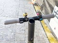 Electric kick scooter handlebar with bell on cobblestone street Royalty Free Stock Photo