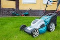 An electric lawn mower in the house backyard