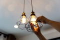 Decorative antique edison style filament light bulbs hanging. An electrician is installing spotlights on the ceiling Royalty Free Stock Photo