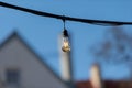 Electric light bulb hang against a blurred blue sky background Royalty Free Stock Photo