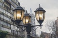 Electric light pole lantern on a city street with two bulb lamps Royalty Free Stock Photo