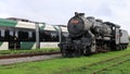 The electric light rail overtaking the steam locomotive symbolizes the evolution of the times and the progress of science.