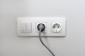 Electric light switch and socket on the empty wall, electrical power socket and plug switched. The concept of energy savings