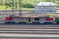 Electric locomotive with freight carriages passes through the railway station