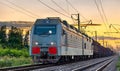 Electric locomotive hauling a cargo train at sunset Royalty Free Stock Photo