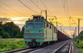 Electric locomotive hauling a cargo train at sunset Royalty Free Stock Photo