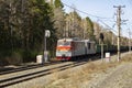 An electric locomotive rushes along a high embankmen