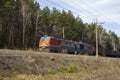 An electric locomotive rushes along a high embankmen