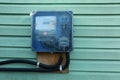 Electric meter on turquoise wooden wall outdoors, space for text. Measuring device