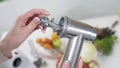 Female hand assembles meat grinder head for providing quality mince frommeat. Electric mincer machine for minced meat