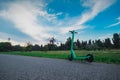 An electric mobility scooter left all alone in the park. Green scooter in a green environment, green energy Royalty Free Stock Photo