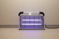 Electric Mosquito and Insect Zapper With Blue Purple Lights Turned on. Bug Killer Lamp on