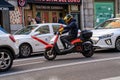 electric motorcycle for rent by the minute driven on gran via street in madrid between several cars Royalty Free Stock Photo