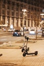 Electric motorized rental scooters parked on urban city street near sunset selective focus low angle