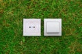 Electric outlet and light switch on a grass Royalty Free Stock Photo