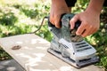 craftsman smoothing rough wood using an electric planing tool. Royalty Free Stock Photo