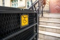 Electric platform lift at building staircase for disabled people with wheelchair sign plate on old city street. Elevator Royalty Free Stock Photo